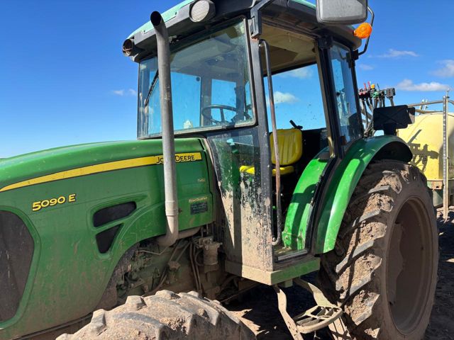 Tractor John Deere en el lote, con la pulverizadora detrás